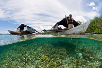 West Papuan fishermen in their outrigger houseboat over the shallow reef. North Raja Ampat, West Papua, Indonesia, February 2010