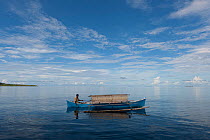 West Papuan fisherman in his outrigger boat. Raja Ampat, West Papua, Indonesia, February 2010.