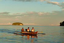 West Papuan fishermen in their outrigger boat. Raja Ampat, West Papua, Indonesia, February 2010.