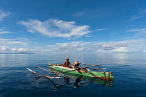 West Papuan fisherman in his outrigger boat. Raja Ampat, West Papua, Indonesia, February 2010.