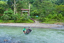 Park staff crossing river to park entrance. Gunung Leuser National Park, North Sumatra, Indonesia, June.