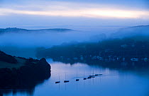 View of boats and estuary, looking toward Southpool Creek from Snape's Point in the early morning light and mist. Salcombe, South Devon, UK, September 2010