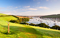 Footpath sign and view from Snape's Point over the fields to the harbour and boats in Kingsbridge estuary. Salcombe, South Devon, UK, September 2010
