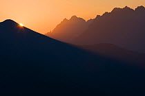 Sun rises behind Mt. Krisna in the Western Tatras, with the High Tatras in the background. Slovakia, August.