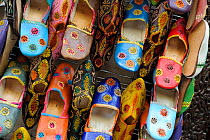 Embroidered shoes on sale in souk / market, Fes, Morocco, December 2010.