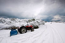 A tractor by a snow-bound road. The heaviest snowfall on Sark in living memory. Channel Islands, UK, December 2010.