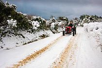 A tractor on a snowy road. The heaviest snowfall in Sark in living memory. Channel Islands, UK, December 2010.
