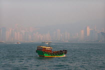 Air pollution in Hong Kong harbour, China, with colourful traditional junk in foreground