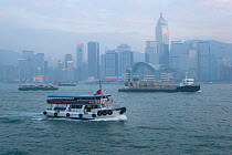 Air pollution in Hong Kong harbour, China, with ferry in foreground