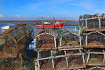 Lobster pots stacked on the quay at Brancaster Staithe, Norfolk, UK, March