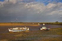 Boats grounded at low tide on coastal creeks, Burham Overy, North Norfolk, UK