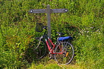 Bicycle beside signpost on the Coast Path, Norfolk, UK