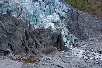 People standing at the base of Fox Glacier, dwarfed by its size, Mount Cook NP, Southern Alps, South Island, New Zealand
