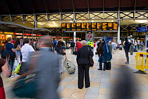 Travellers watching the information board at Paddington Station, London, UK