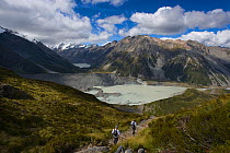Hikers on path approaching the Mueller and Hooker Glacier Lake, Mount Cook National Park, South Island, New Zealand