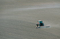 Tractor spring harrowing an arable field, Chilterns, Buckinghamshire, UK