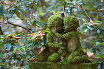 Moss covered statue of angels on the grave of a child, Sydwestkirchhof Stahnsdorf, Berlin, Germany. November 2009
