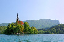 St. Mary of the Assumption church on Bled Island, Lake Bled, with tourists visiting by boat, Slovenia, July 2010.