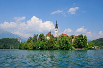 St. Mary of the Assumption church on Bled Island, Lake Bled, with clifftop Bled castle, and the Julian Alps in the background, Slovenia, July 2010.