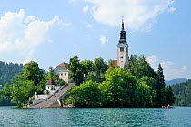 St. Mary of the Assumption church on Bled Island, Lake Bled, with tourists visiting by boat , Slovenia, July 2010.