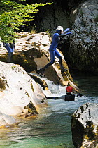 Canyoner leaping into river in Mostnica gorge, near Lake Bohinj, Slovenia, July 2010.