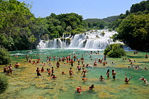 Tourists bathing in pools in the Krka river below Skradinski buk waterfalls, Krka National Park, Sibenik, Croatia, July 2010.