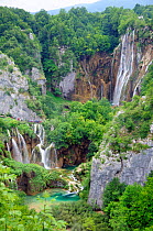 Overview of tourists on boardwalk and bridges, dwarfed by the Great waterfall (Veliki Slap) above and Sastavci waterfall below them, Plitvice Lakes National Park, Croatia, July 2010.