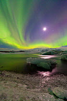 Northern lights (Aurora Borealis) and moon in sky above Jokulsarlon glacier lagoon. Southern Iceland, Europe, March 2011.