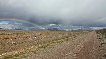 Remote dirt track and rainbow. Route 40, Argentina, Patagonia, South America, March 2010.