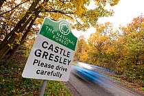 The National Forest road sign at Castle Gresley with blurred car in the background, autumn, Derbyshire, UK, November 2010.