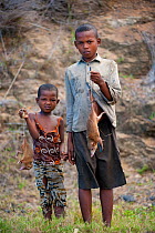 Children selling Common Tenrecs (Tenrec ecaudatus) as bushmeat by a road. North Madagascar, Africa.