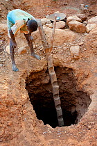 A man looking down a gold exctraction hole. Daraina protected area, North Madagascar, Africa, November 2010.