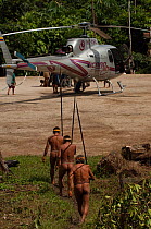 Huaorani indians approaching a helicopter in an interesting contrast of culture. Gabaro Community. Yasuni National Park, Ecuador, June 2007.