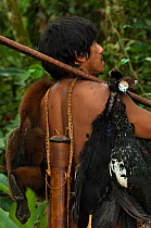 A Huaorani hunter in the forest with bushmeat (a Woolly Monkey, Trumpeters, Guans) he has taken using his blowgun. Gabaro Community. Yasuni National Park, Ecuador, June 2007. Model release #CO25.