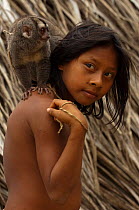 Huaorani Indian girl with her night monkey (Aotus) pet. Gabaro Community, Yasuni National Park, Ecuador, June 2007.