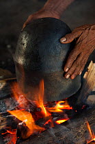 Huaorani Indian clay pot being dryed on the fire after use. Gabaro Community, Yasuni National Park, Ecuador, June 2007.