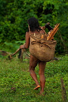 Huaorani Indian woman carrying fire wood. Gabaro Community, Yasuni National Park, Ecuador, June 2007. Model release #GA20.