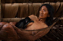 Huaorani Indian woman with her pet White-bellied Spider Monkey (Ateles belzebuth). They would have hunted the mother for meat and raised the baby as their pet. Gabaro Community, Yasuni National Park,...