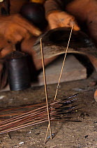Huaorani Indian making Curare tipped darts. Curare is one of the most toxic poisons known to man and is made from a liana. The poison is boiled on the fire. The dart tips are dipped into the poison wh...