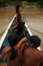 Huaorani Indians in motor canoe. Bameno Community, Yasuni National Park, Ecuador, May 2007.