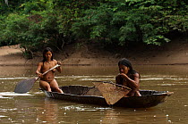 Two Huaorani Indian women in a canoe. One has a fishing net. Bameno Community, Yasuni National Park, Ecuador, May 2007.