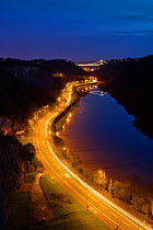Long exposure view of the Avon Gorge at night, with the lights of cars on the road and the illuminated Clifton Suspension Bridge. Bristol, UK, November 2009