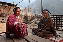 Monpa lady with her father in typical Monpa dress and head dress, made from Yak hair. Chaksam village near Tawang, Arunachal Pradesh, India, February 2011.