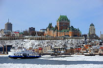 Frontenac Castle and St Lawrence river ferry boat in melting ice. Quebec, Canada, March 2011.