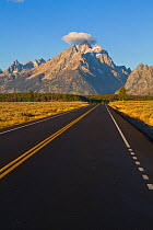 Road stretching towards dramatic mountain peaks. Grand Teton National Park, Wyoming, September 2010.