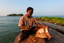 Carver Huimes Namusu carving a bowl out of piece of coconut tree trunk, Marovo Lagoon, Solomon Islands, Melanesia, Pacific, July 2010.