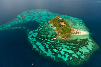 Aerial view of private tropical island surrounded by a white sandy beach and coral reefs, note helipad on end of pier, Palawan, Philippines, May 2009.