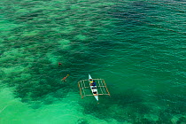 Aerial view of farmers on outrigger boat working at a seaweed farm growing agar-agar for processing into carageenan (gelatinous extracts used as binder for food or product) Philippines, May 2009.