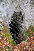 Entrance to cave pwith iron gate for the protection of bats as a project of nature conservation. Ardennes, Belgium, March 2011.