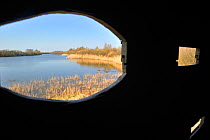 View from inside a bird hide over lake in the nature reserve Parc du Marquenterre. Bay of the Somme, Picardy, France, March 2011.